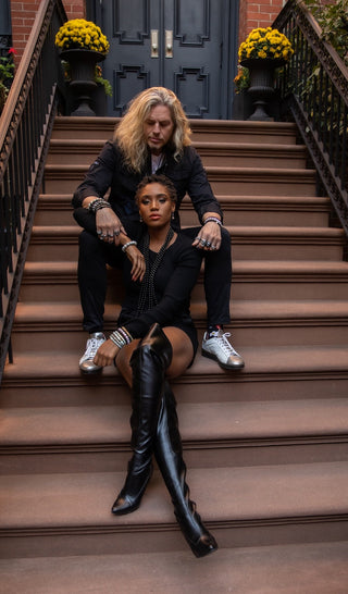 Two people sitting on a set of stairs with decorative elements and flowers.
