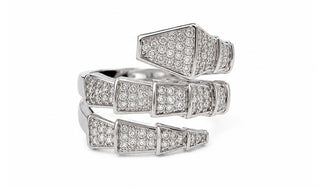 A silver-tone ring with three stacked, geometric snake-bone style bands paved with small clear stones, shown on a plain white background.