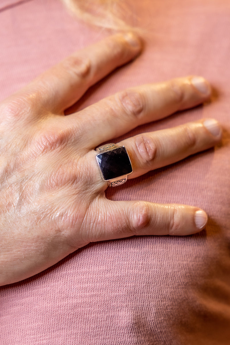 Man wearing sterling silver faceted onyx ring.