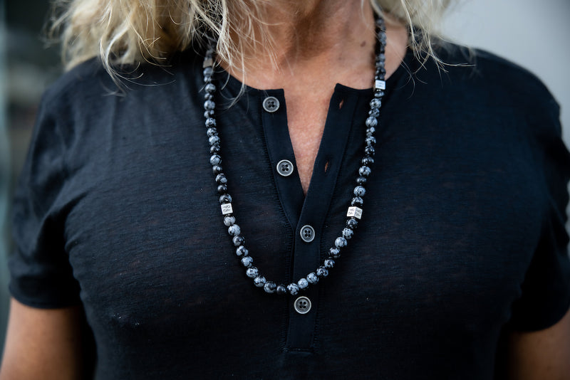 Alt= Male wearing snowflake obsidian necklace with black shirt.