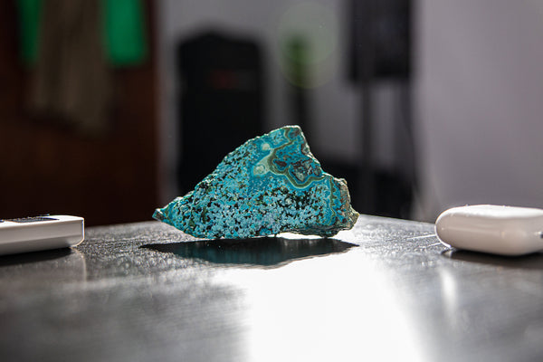Malachite and Chrysocolla Geode Cluster sitting on desk.
